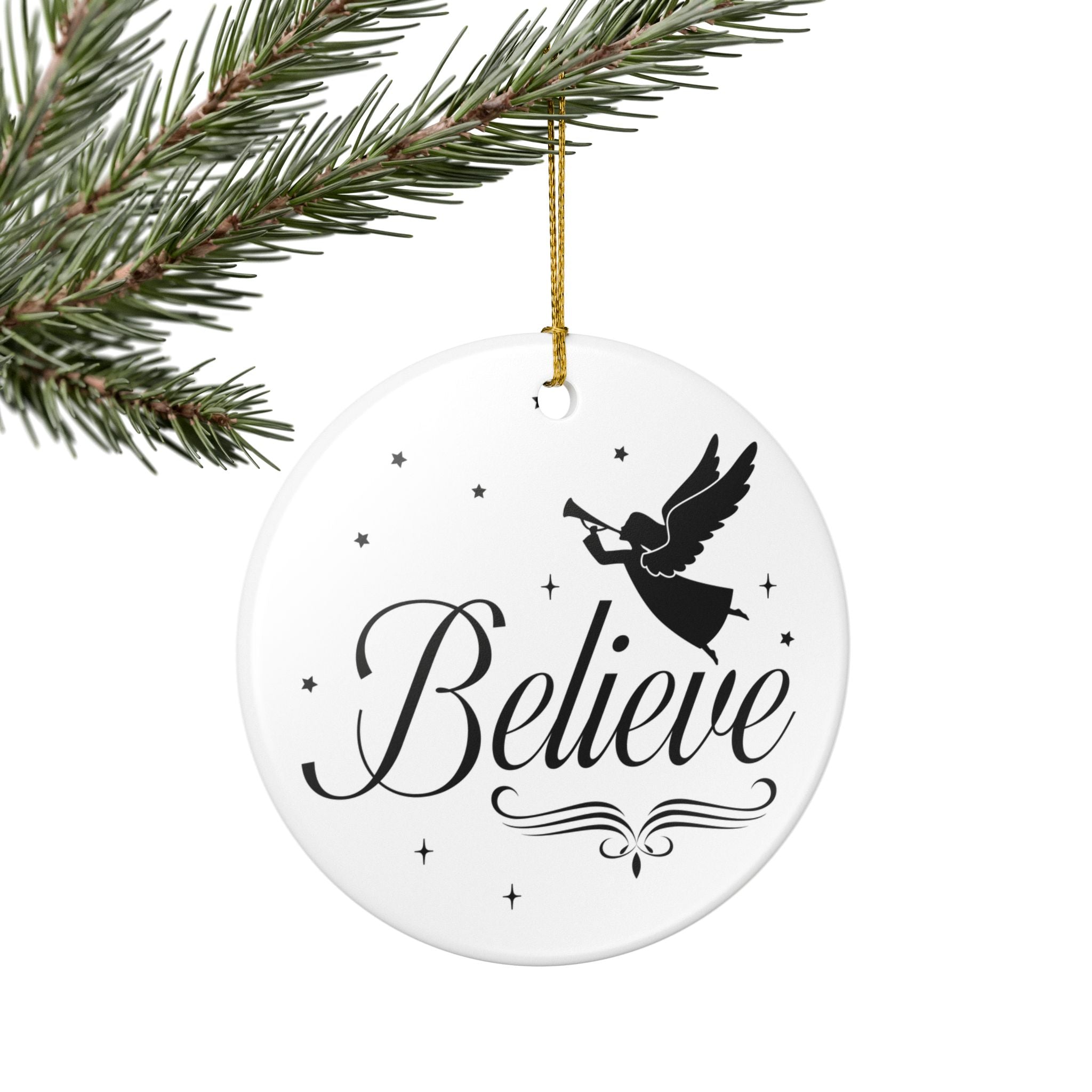 Front view of White ceramic Christmas ornament with graphic displaying stars, an angel, and text that says Believe. Hanging on a branch.