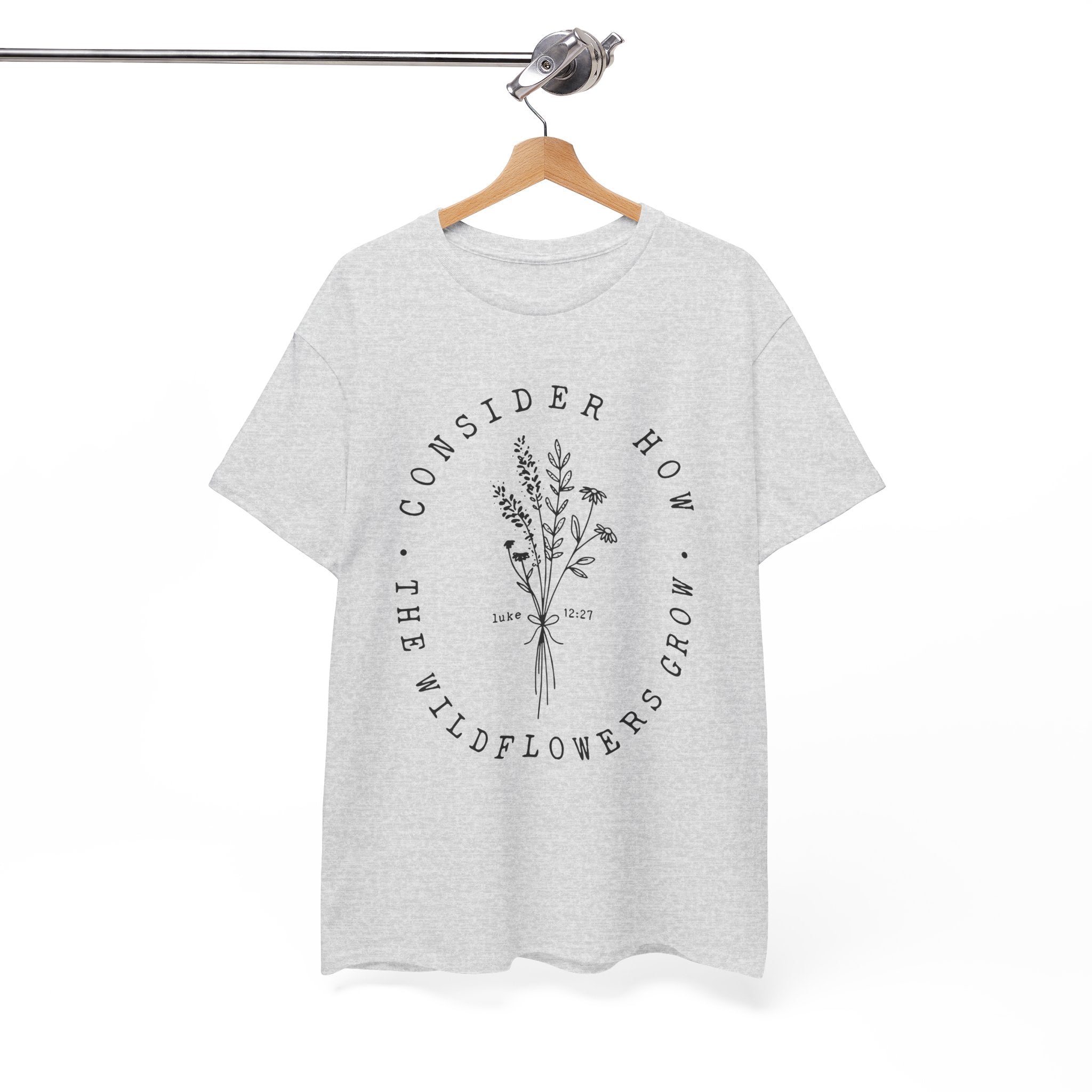 Front view Ash t-shirt with large black floral graphic and Luke 12:27 Bible verse displayed on a hanger