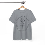 Front view Gravel t-shirt with large black floral graphic and Luke 12:27 Bible verse displayed on a hanger