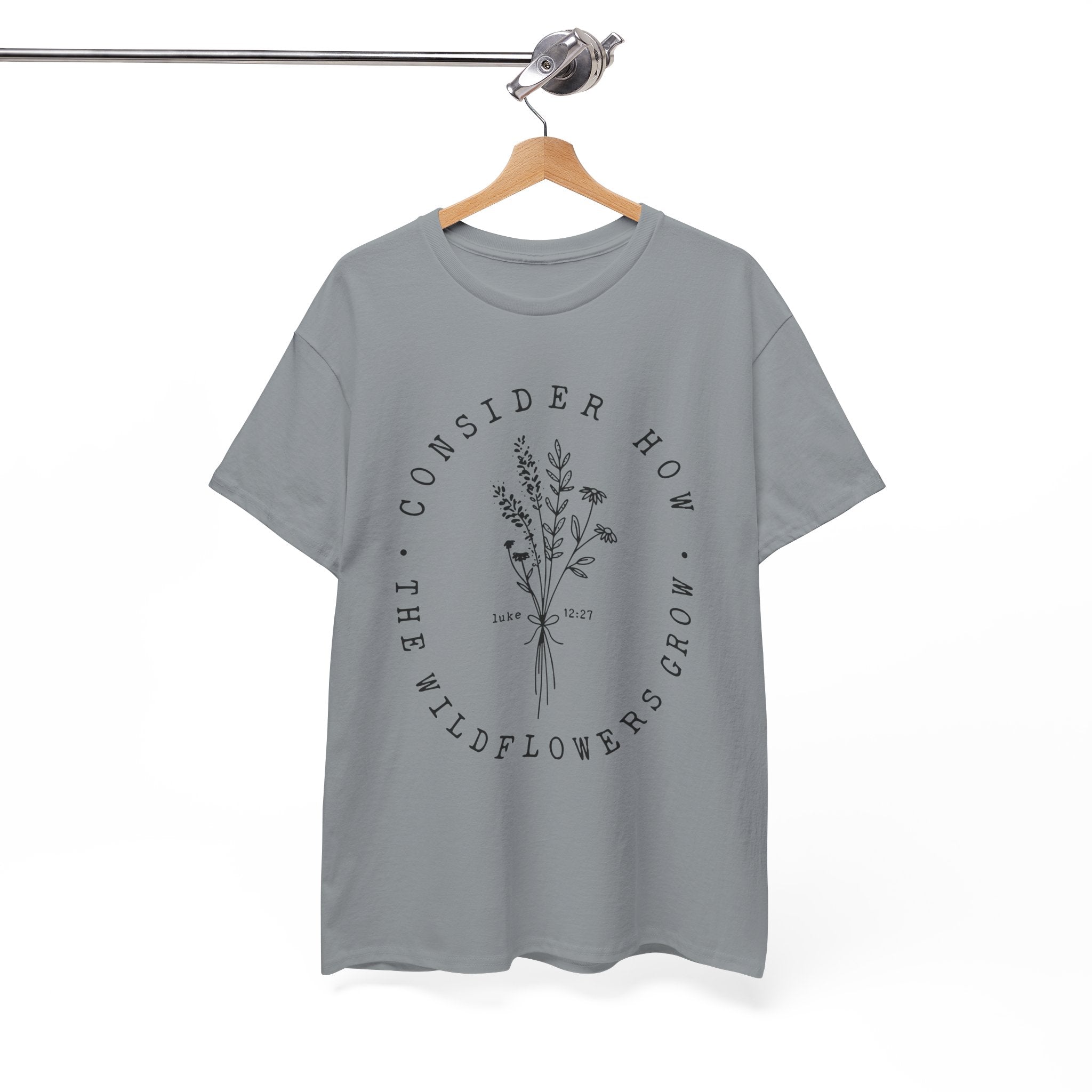 Front view Gravel t-shirt with large black floral graphic and Luke 12:27 Bible verse displayed on a hanger