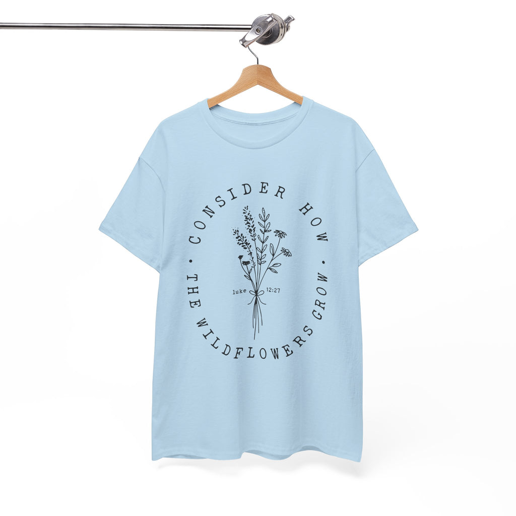 Front view Light Blue t-shirt with large black floral graphic and Luke 12:27 Bible verse displayed on a hanger