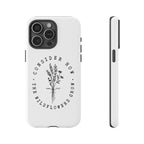 White iPhone case with black floral graphic and Luke 12:27 Bible verse displayed on an iPhone 15 Pro Max
