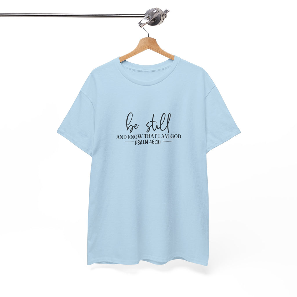 Front view of Light Blue t-shirt with black text Be Still And Know That I Am God Psalm 46:10 centered on chest. Shirt is displayed on a hanger.