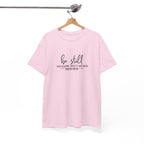 Front view of Light Pink t-shirt with black text Be Still And Know That I Am God Psalm 46:10 centered on chest. Shirt is displayed on a hanger.