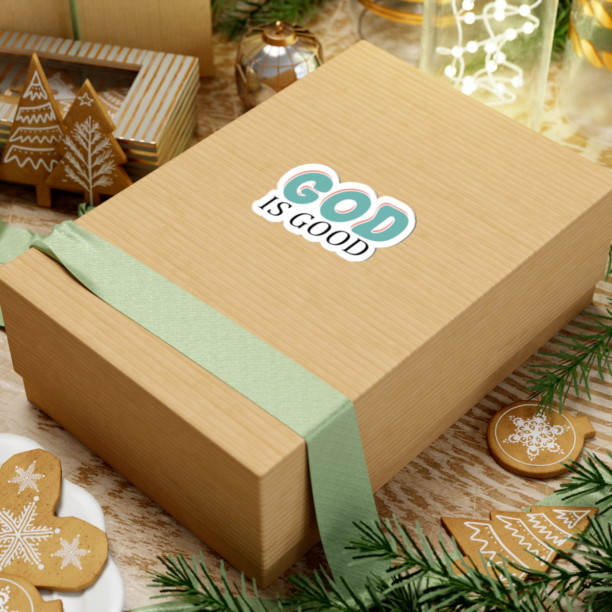 Retro-style sticker with colorful text saying God Is Good. Displayed on the center of a gift box.