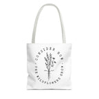Front view of small White tote bag with white handles and large black floral graphic and Luke 12:27 Bible verse