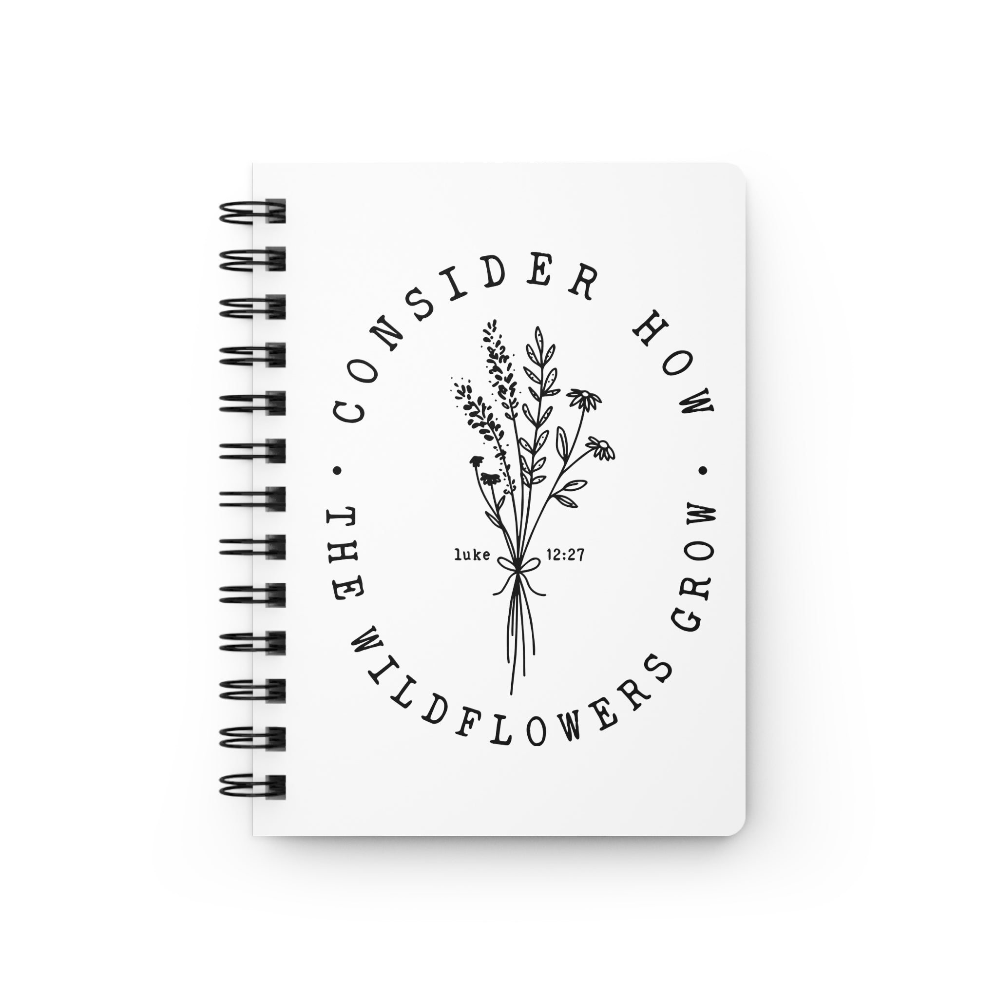 Front view White spiral bound journal with black floral graphic and text from the Bible verse Luke 12:27