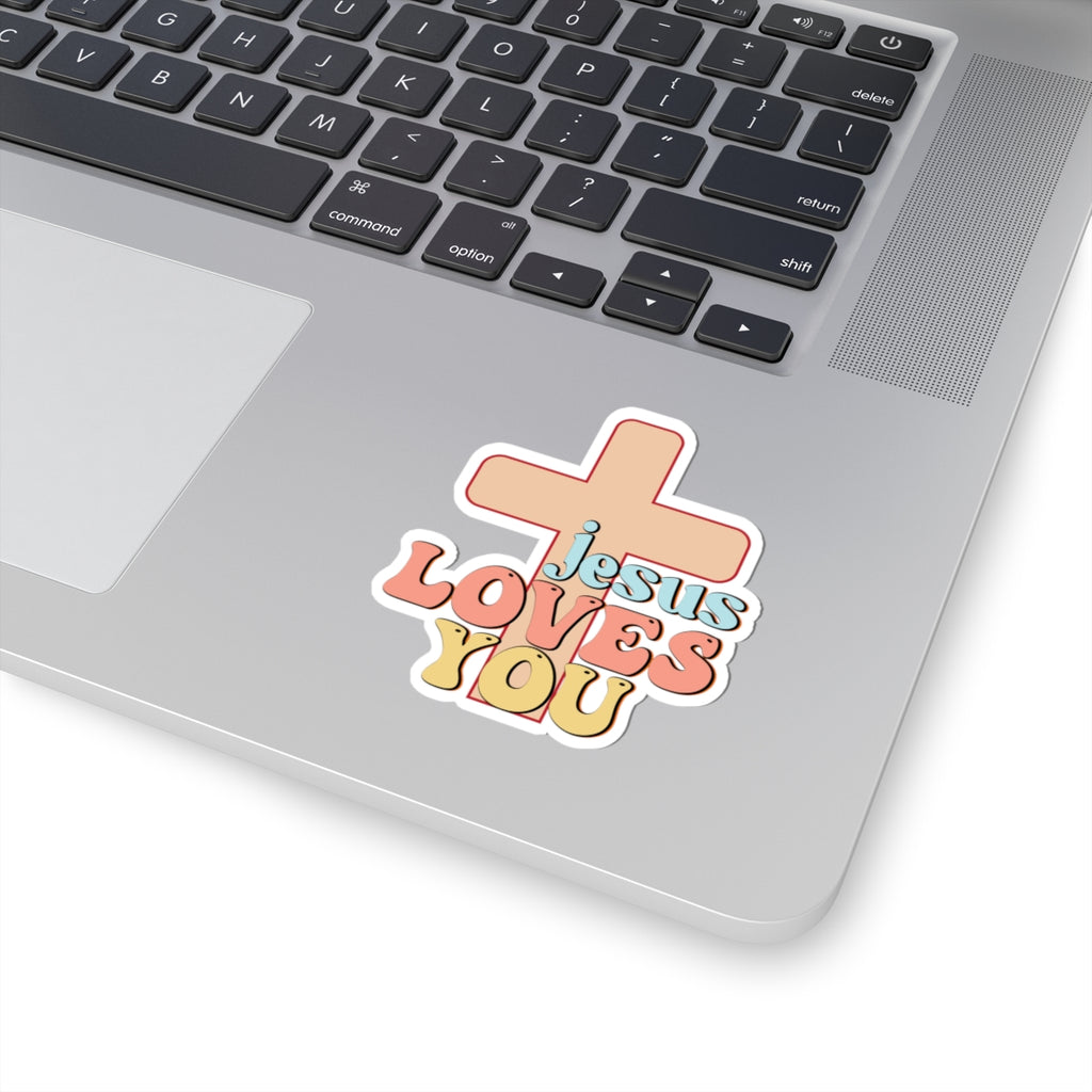 Sticker with colorful graphic and text saying Jesus Loves You. Displayed on laptop.